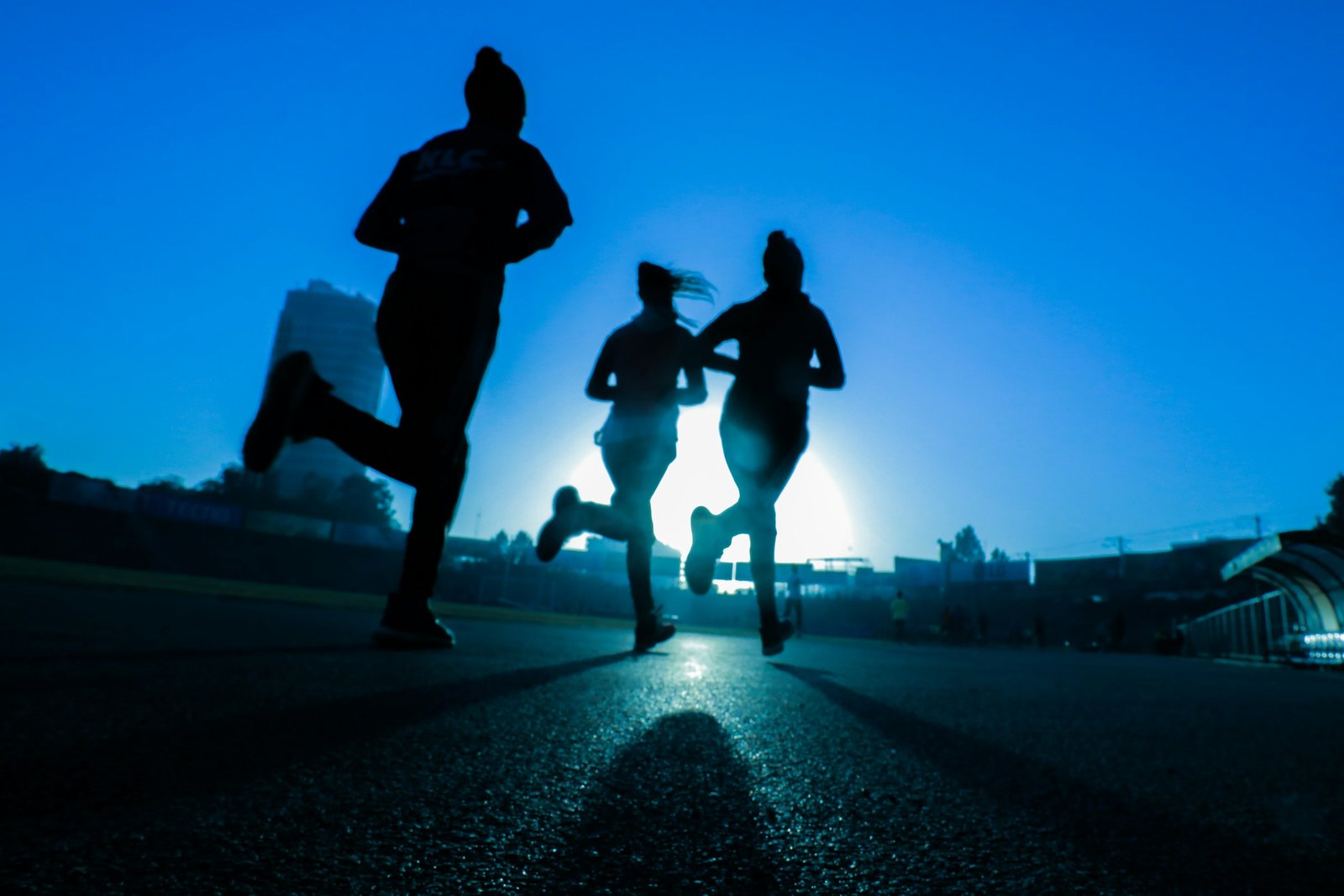 Three runners training outdoors at sunrise