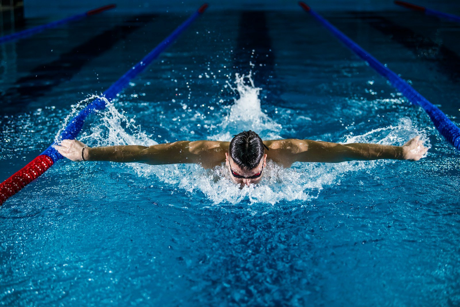 Swimmer completing a butterfly stroke in a pool